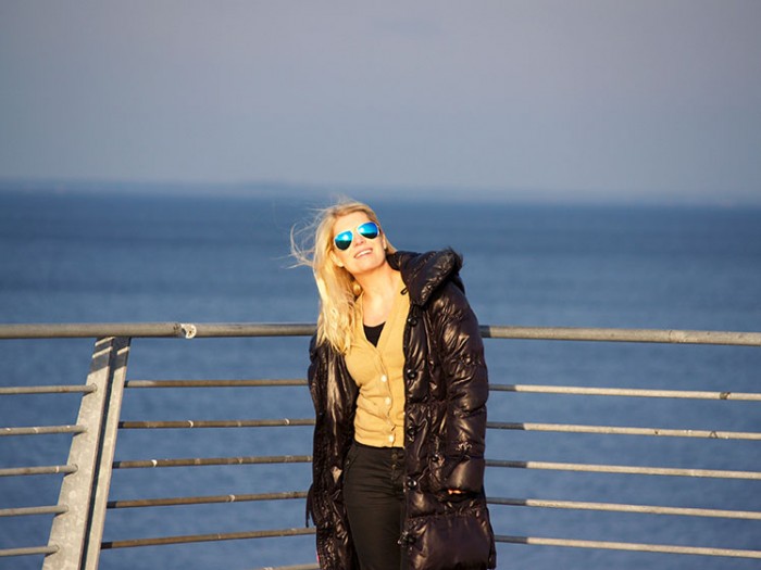 Outfit by the sea in j crew cashmere boyfriend cardigan, black down jacket, sorel boots and denim hunter jeans