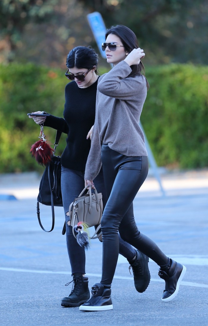 Kylie Jenner in leather leggins and heeled sneakers