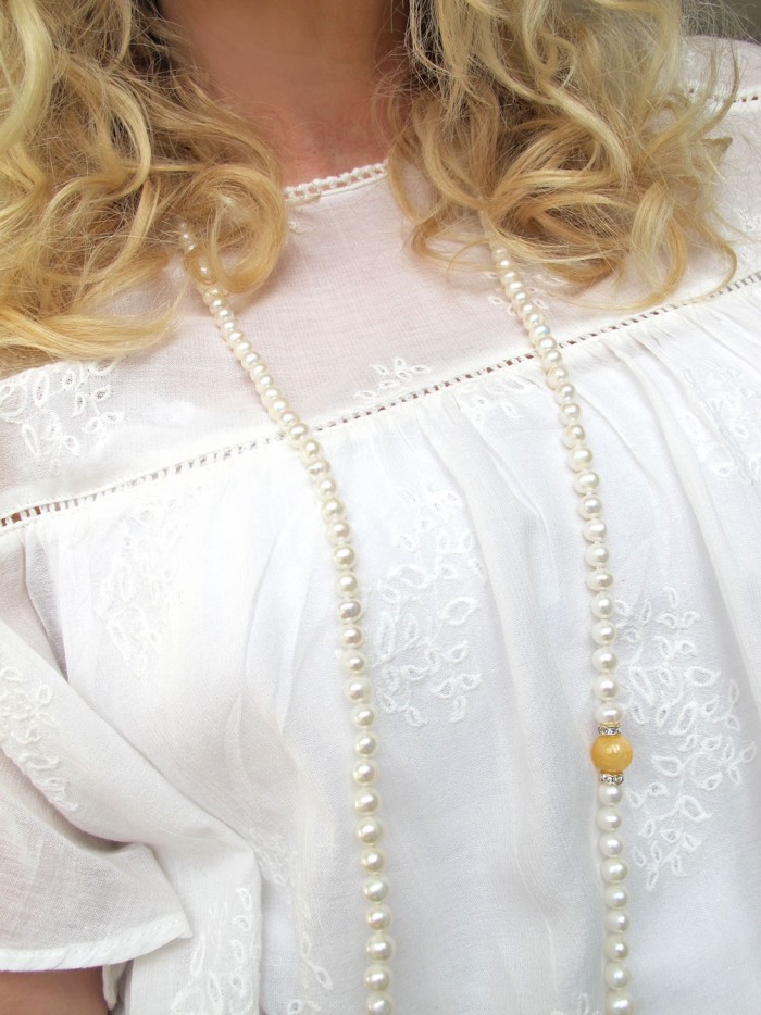 curly hair and long pearl necklace