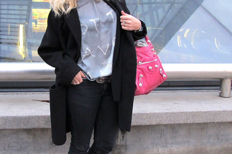 Soulcityguide blogger in front of Malmo Central Station in oversize coat, denim hunter top and pink Balenicaga bag